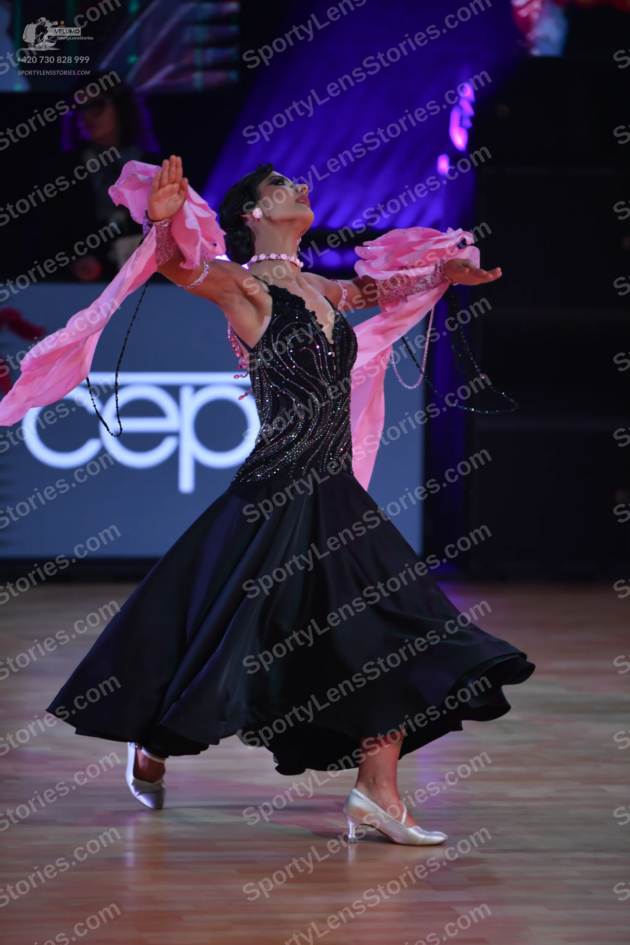 Dancesport competitor: Female dancer: black ballroom gown featuring a heavily sequined/crystal-embellis