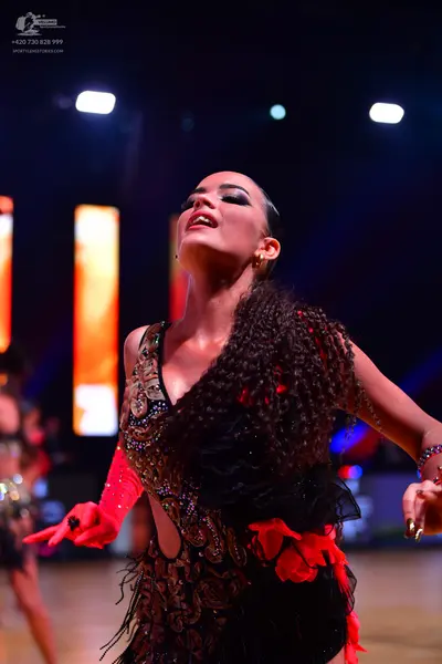 Dancesport competitor: Female dancer: black latin dress with gold and silver sequin and bead embellishm