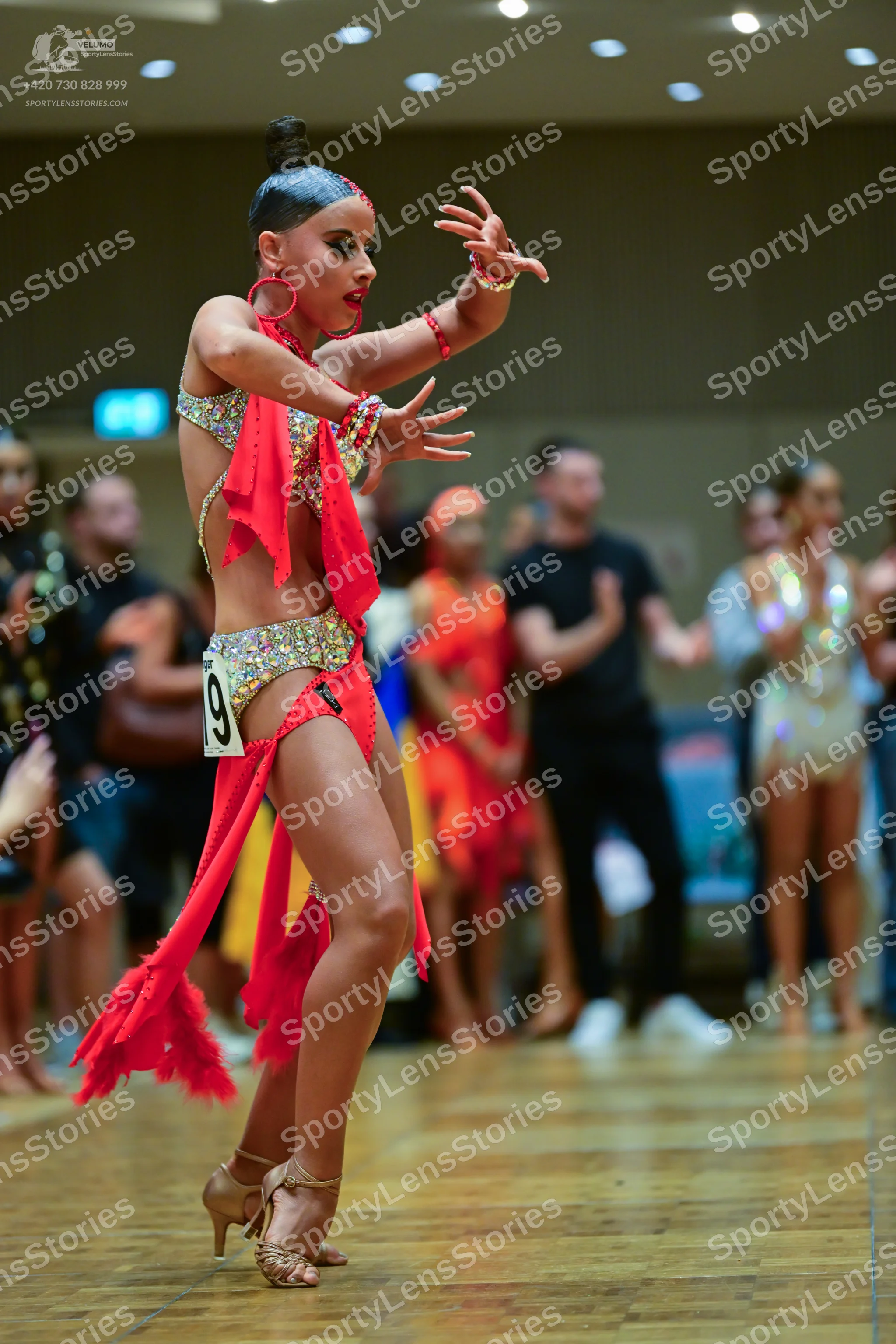 Dancesport competitor: Main female dancer: red latin dress with fringe and multicolored sequins, red ho