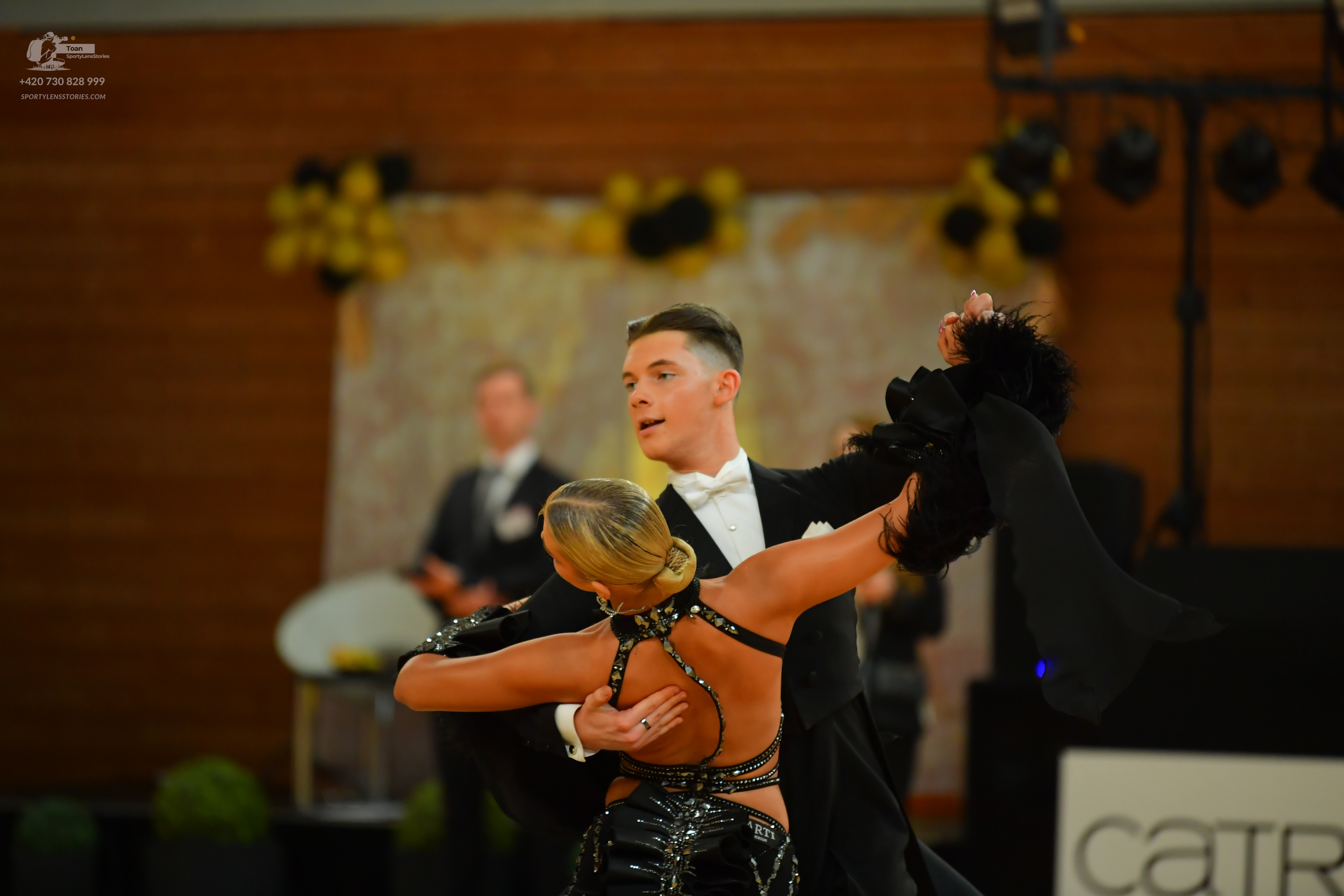 Dancesport competitor: Male:** Black tail suit with black sequin lapels, black fabric, and a black bow 