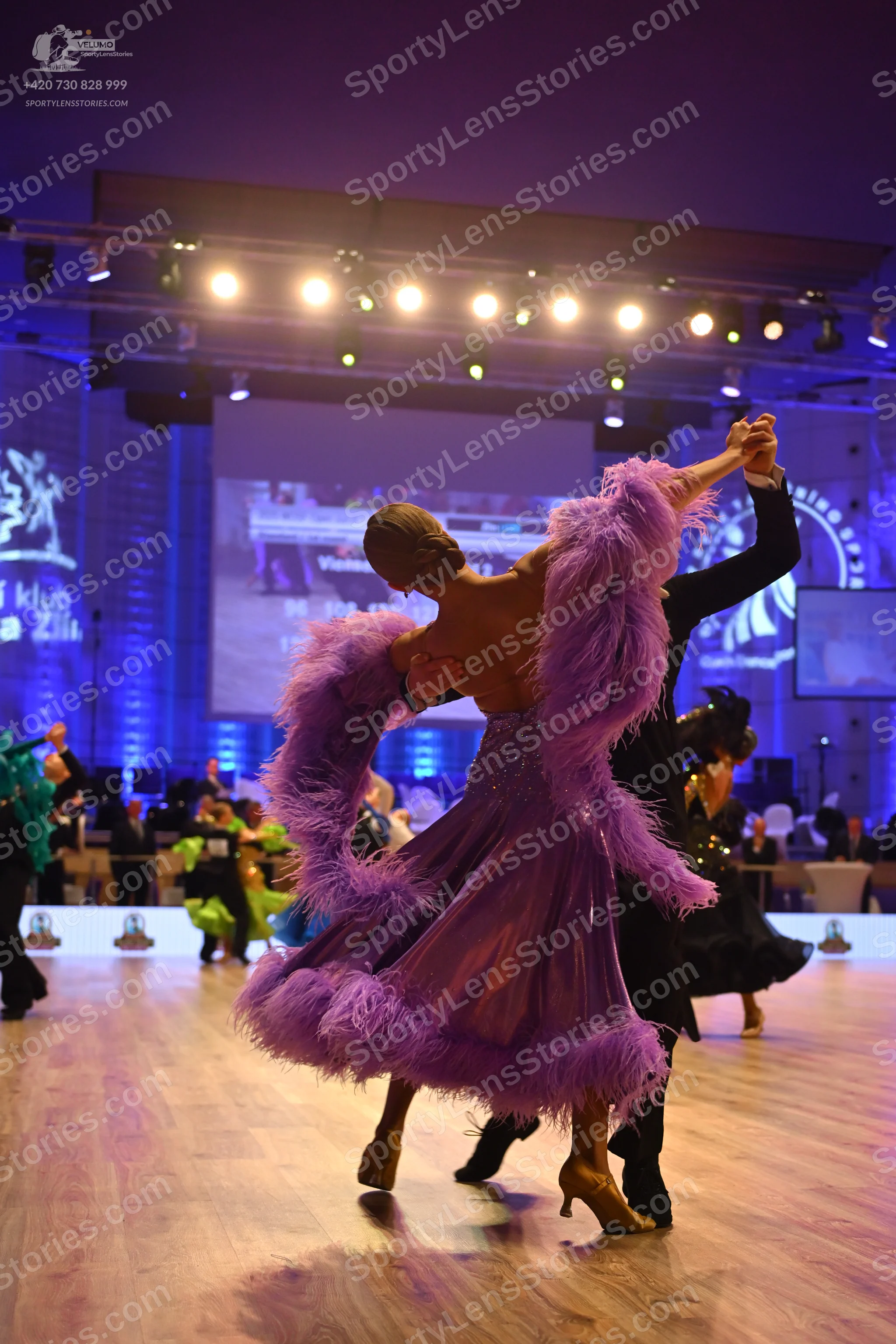 Dancesport competitor: Female dancer: Dramatic purple ballgown featuring an extremely voluminous, large