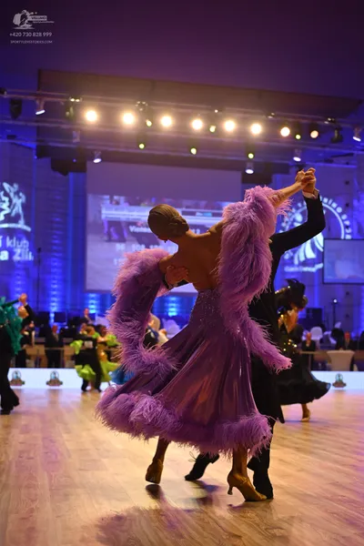 Dancesport competitor: Female dancer: Dramatic purple ballgown featuring an extremely voluminous, large