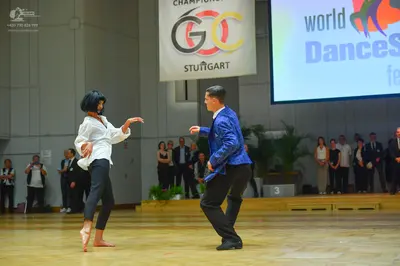 Dancesport competitor: Female dancer: white long-sleeved blouse and black trousers