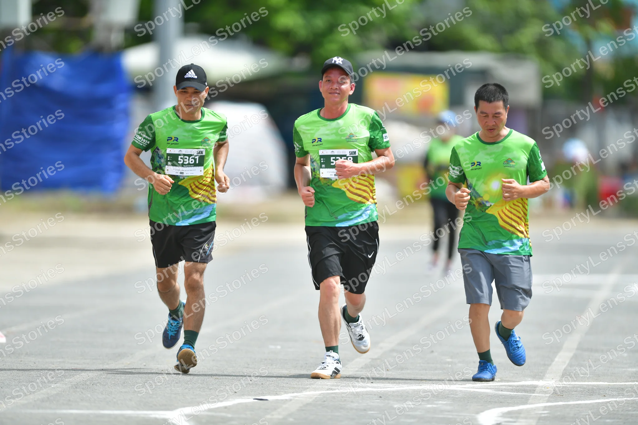 Marathon runner #5361: Runner 1: green and yellow jersey, black shorts, blue shoes, black cap