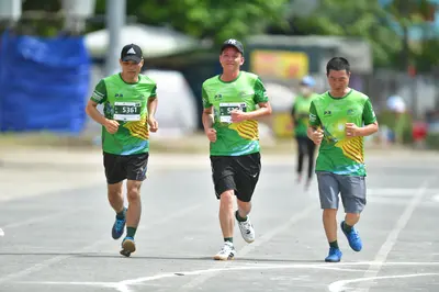 Marathon runner #5361: Runner 1: green and yellow jersey, black shorts, blue shoes, black cap