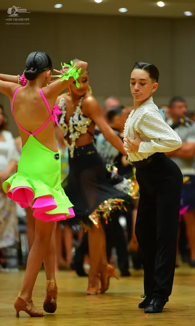 Dancesport competitor: Female dancer 1: lime green latin dress with pink straps and pink ruffled hem