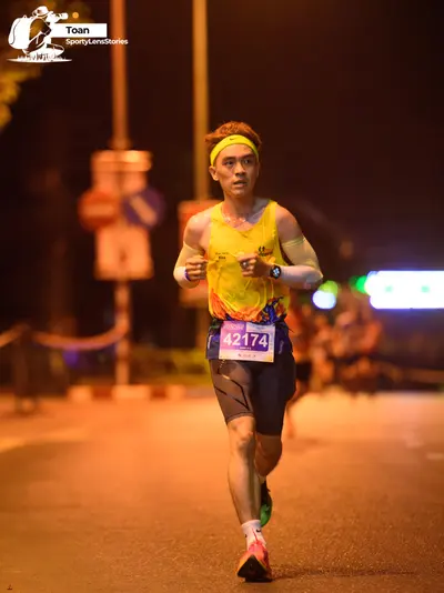 Marathon runner #42174: Runner 1: yellow and orange patterned tank top, dark grey shorts, yellow headban
