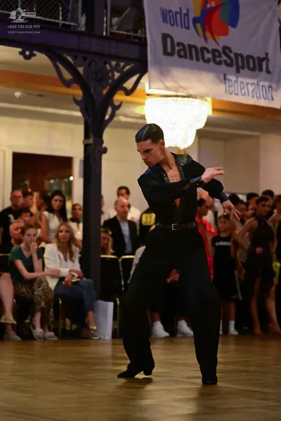 Dancesport competitor: Male dancer: black long-sleeved shirt and black trousers