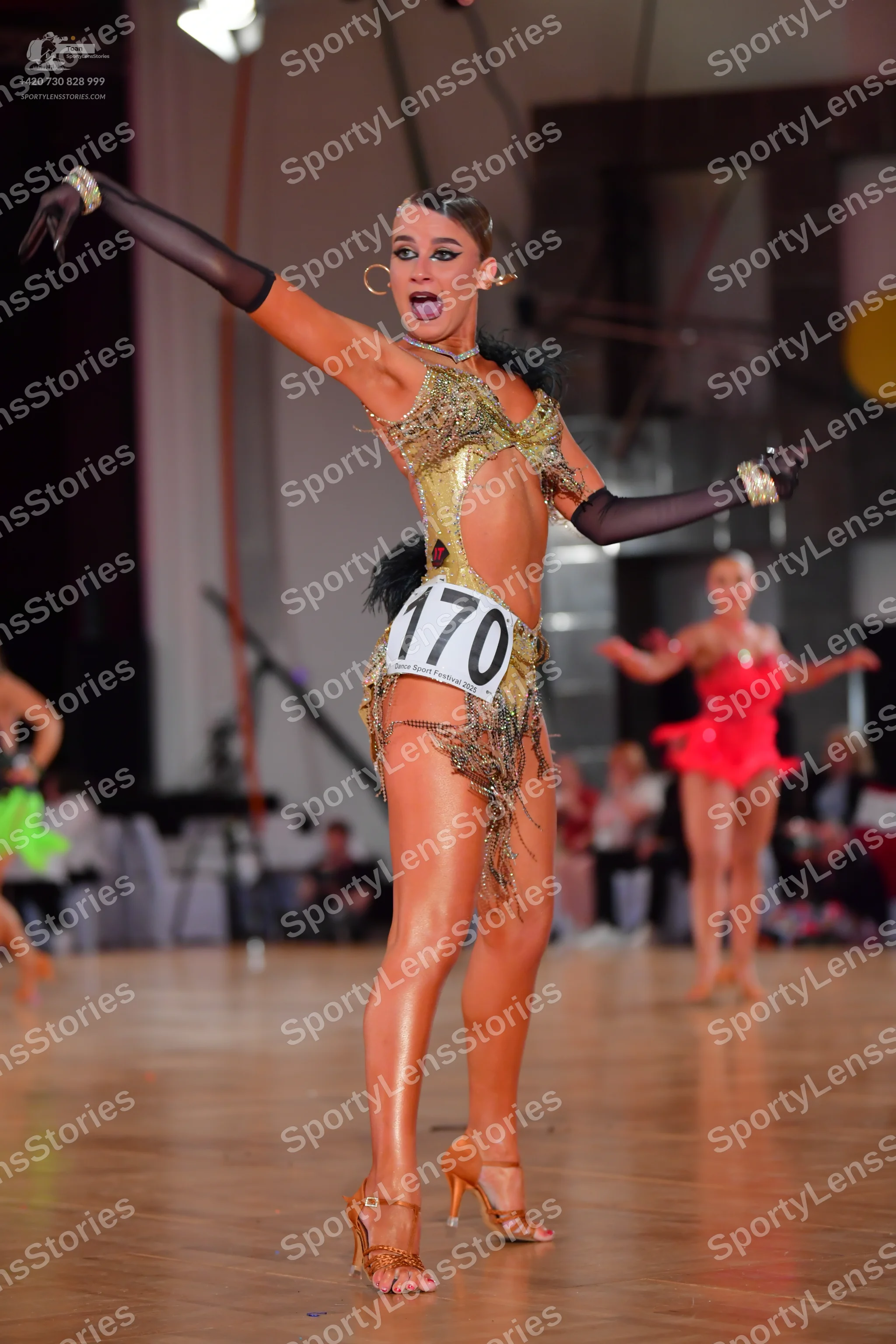 Dancesport competitor #170: Female dancer in foreground: gold Latin dance costume with sequins and fringe, a