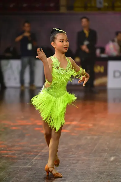 Dancesport competitor: Female dancer: lime green Latin dress with fringe and sequins