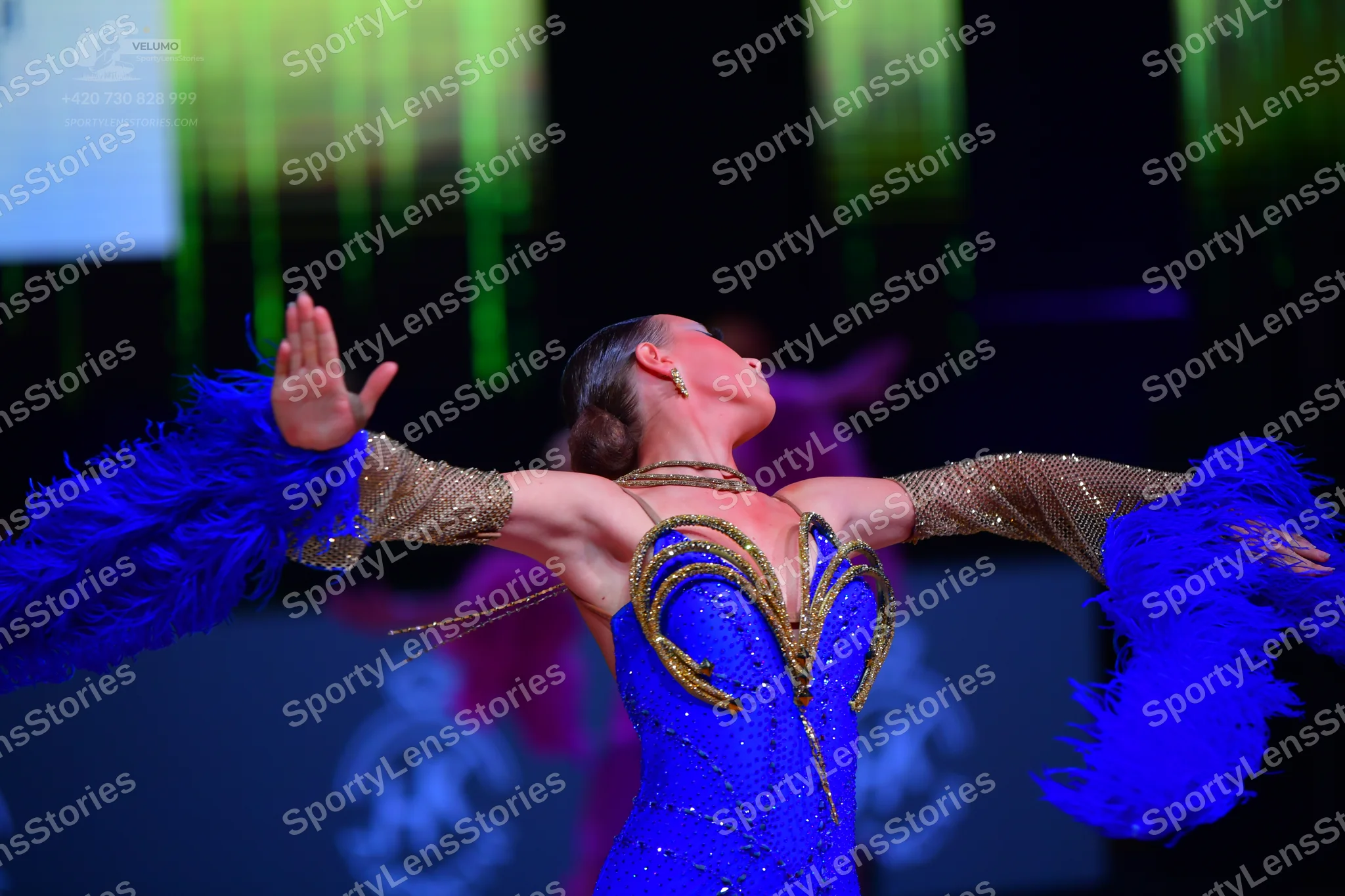 Dancesport competitor: Female dancer: blue Latin dress with a gold and bronze sequined bodice and sheer