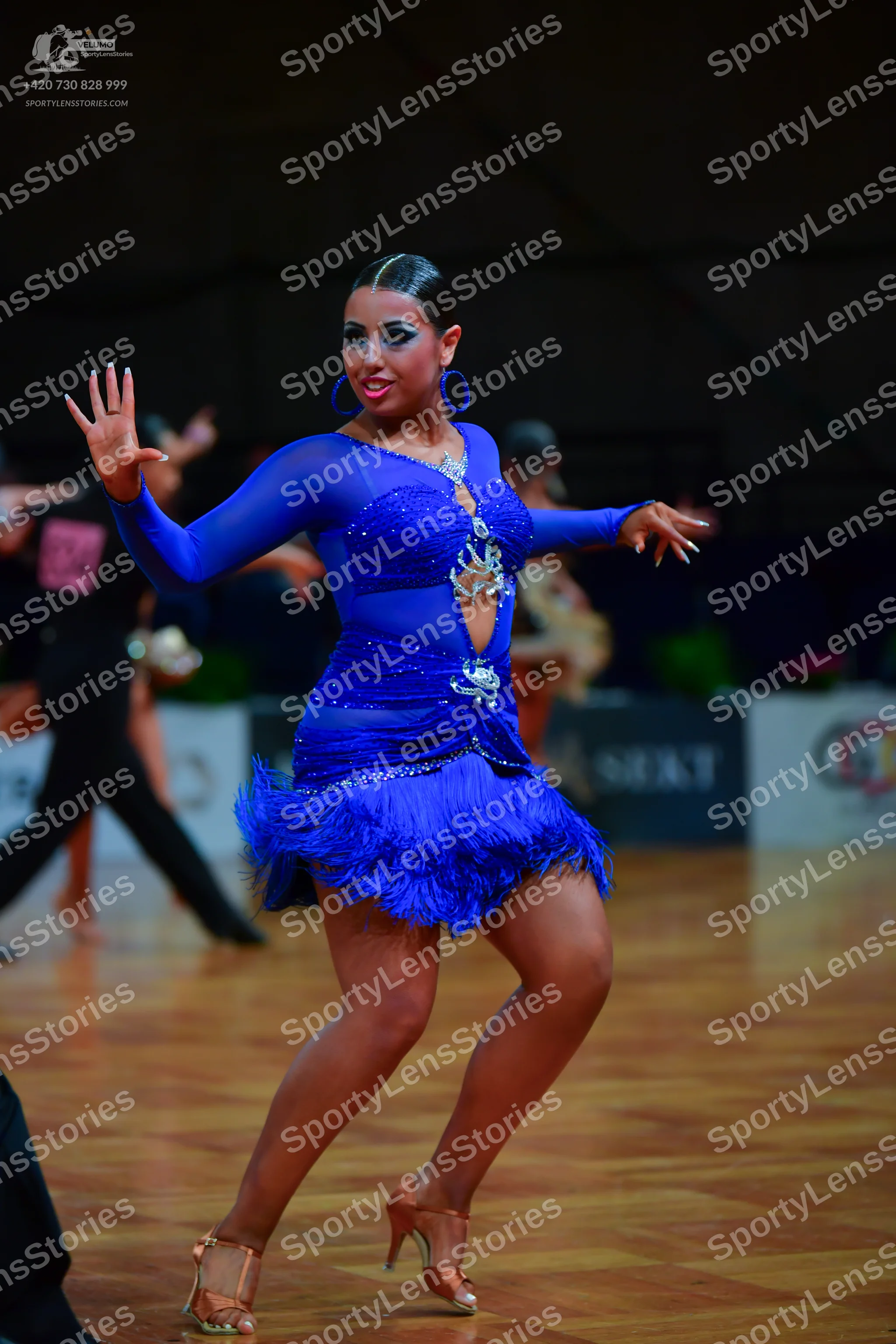 Dancesport competitor: Female dancer: blue Latin dance dress with long sleeves, rhinestone embellishmen