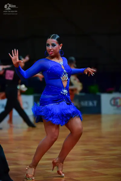 Dancesport competitor: Female dancer: blue Latin dance dress with long sleeves, rhinestone embellishmen