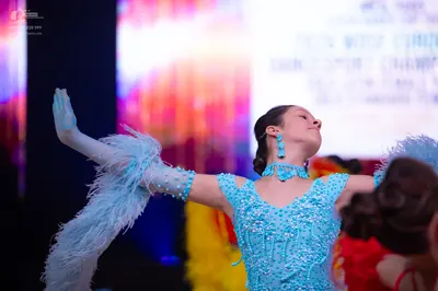 Dancesport competitor: Female dancer: light blue/cyan Latin dance dress heavily embellished with sequin