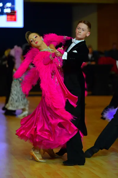 Dancesport competitor: Male dancer: black tuxedo with a white shirt, white bow tie, and a white pocket 