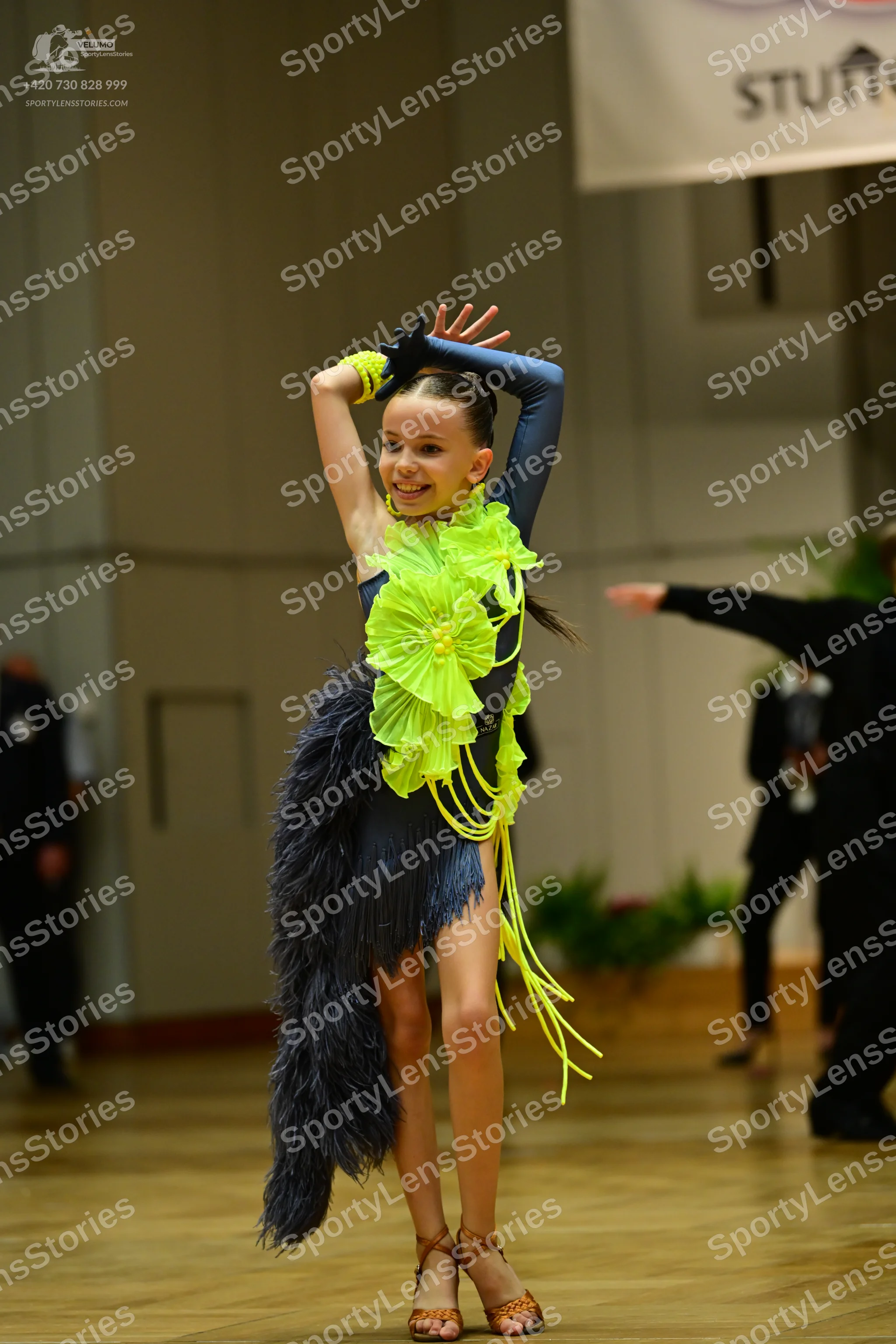 Dancesport competitor: Female dancer: navy blue Latin dance dress with lime green ruffles on the bodice