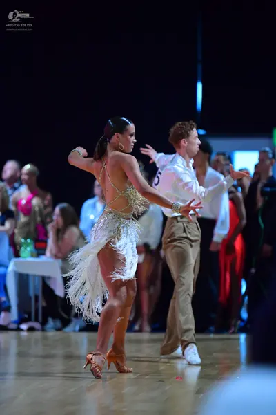 Dancesport competitor: Female dancer: white Latin dance dress with sequin embellishments and long fring