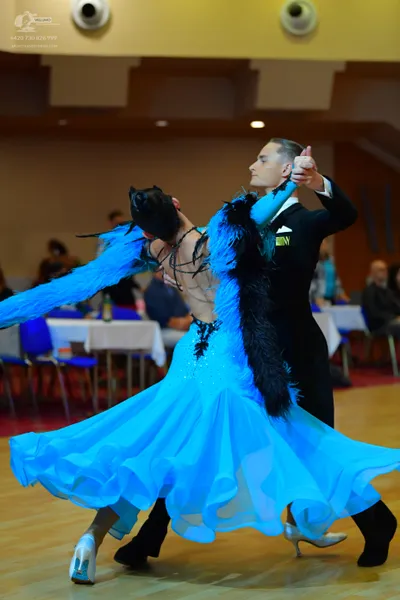 Dancesport competitor: Female dancer: bright blue ballroom dress with a large, flowing, multi-layered s