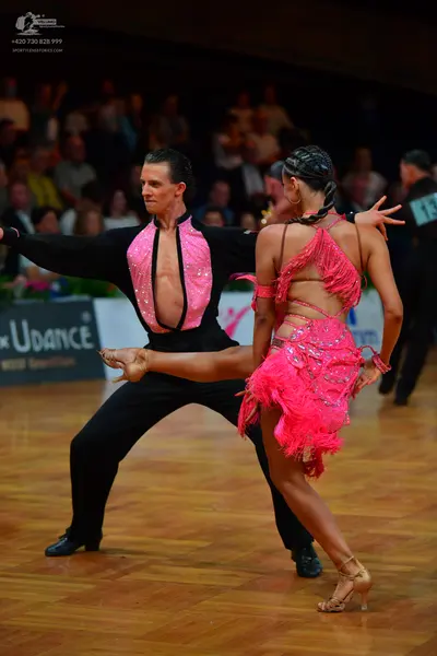 Dancesport competitor #18: Male dancer: black long-sleeved shirt with a vertical pink panel and black trous