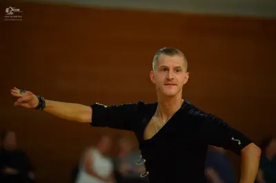 Dancesport competitor: Male dancer: black long-sleeved dance shirt with metallic buckle/clip details