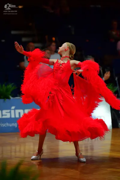 Dancesport competitor: Female dancer: red Latin dress with long, voluminous fringe