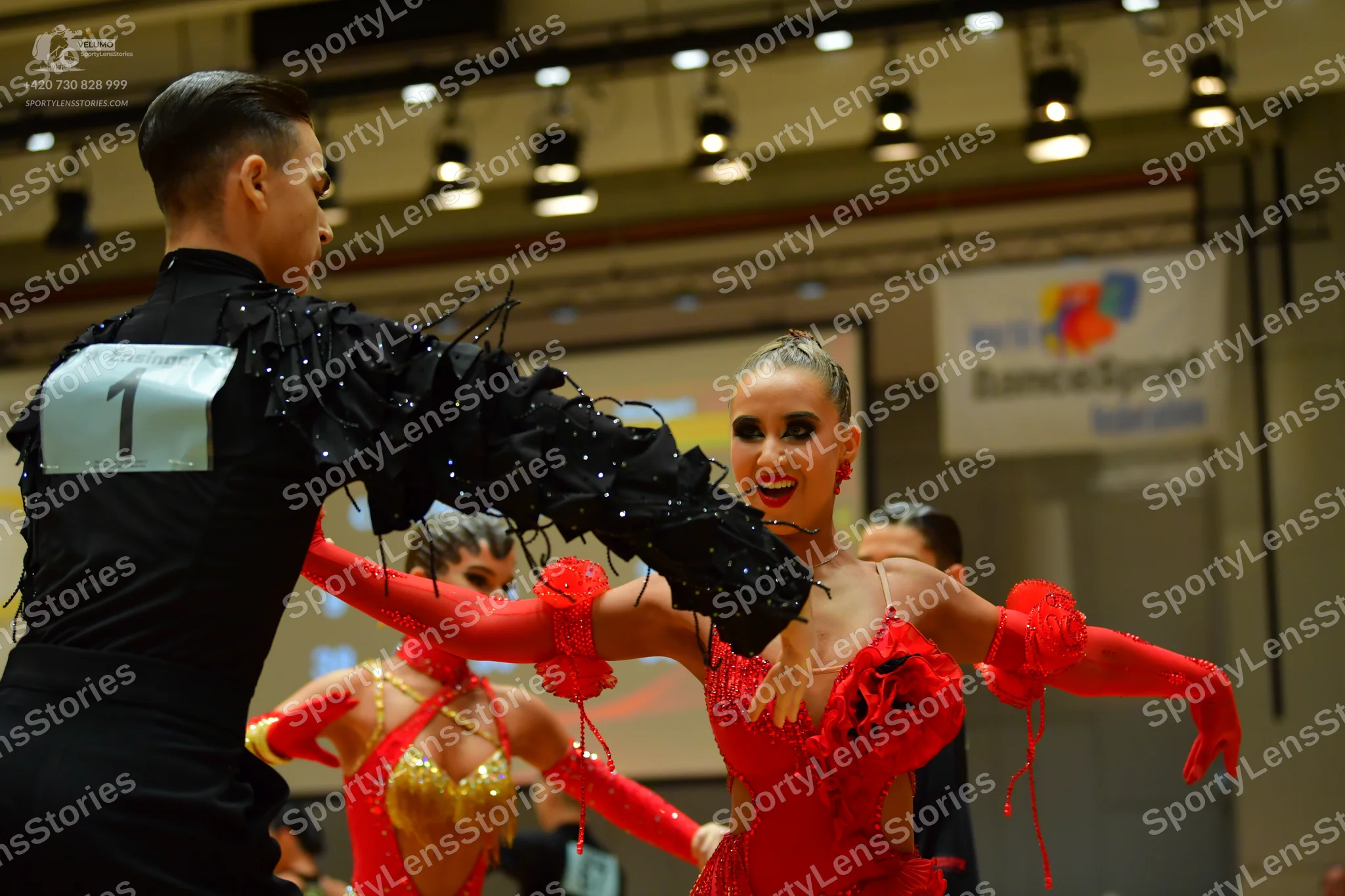 Dancesport competitor: Male dancer: black long-sleeved shirt with black feathered or fringed sleeve det