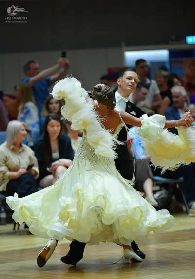 Dancesport competitor: Female dancer: voluminous pale yellow/cream ballgown with ruffled layers, sequin