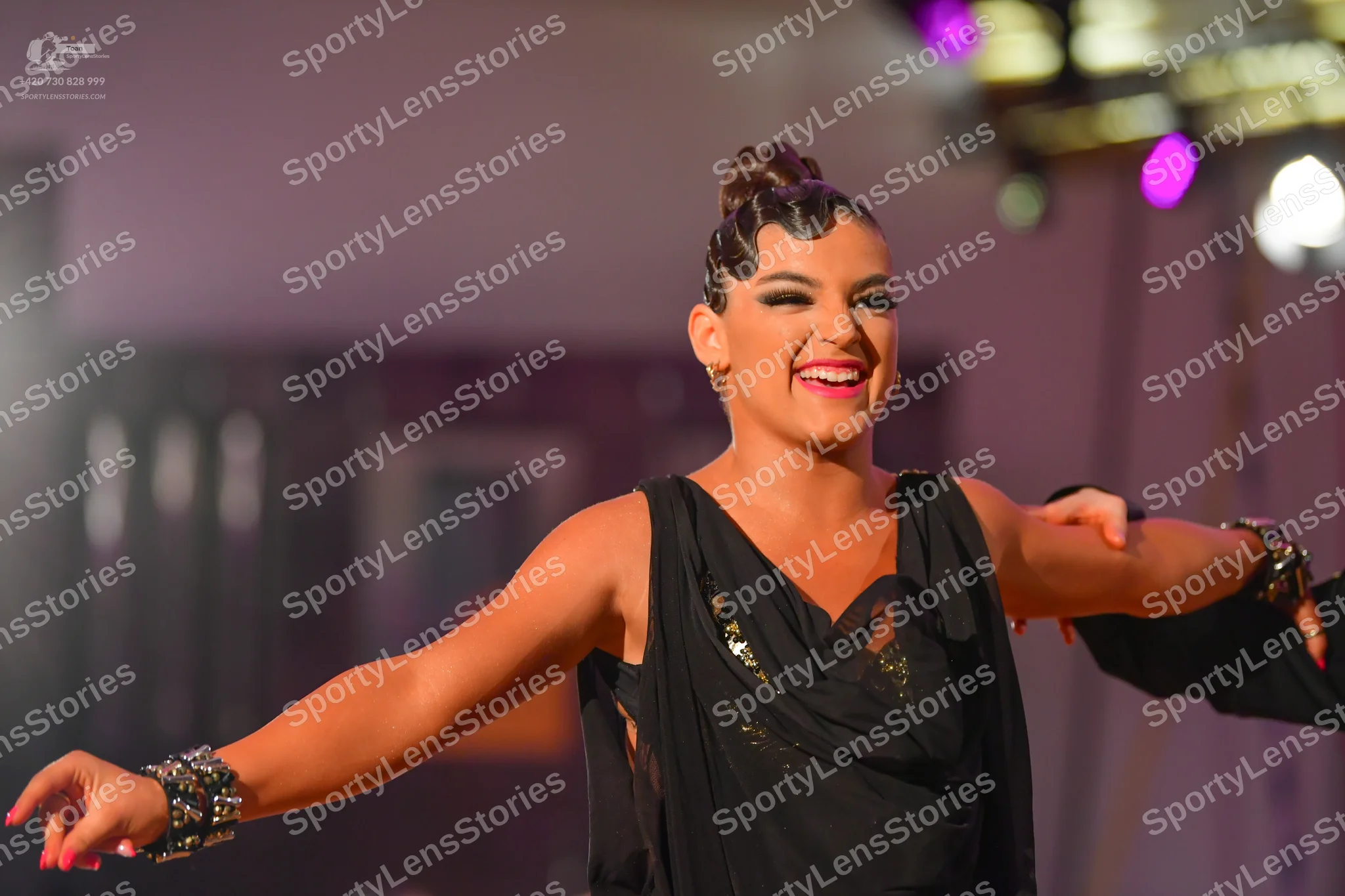 Dancesport competitor: Female dancer: black sleeveless Latin costume with sequin embellishments and lar