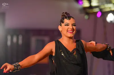 Dancesport competitor: Female dancer: black sleeveless Latin costume with sequin embellishments and lar