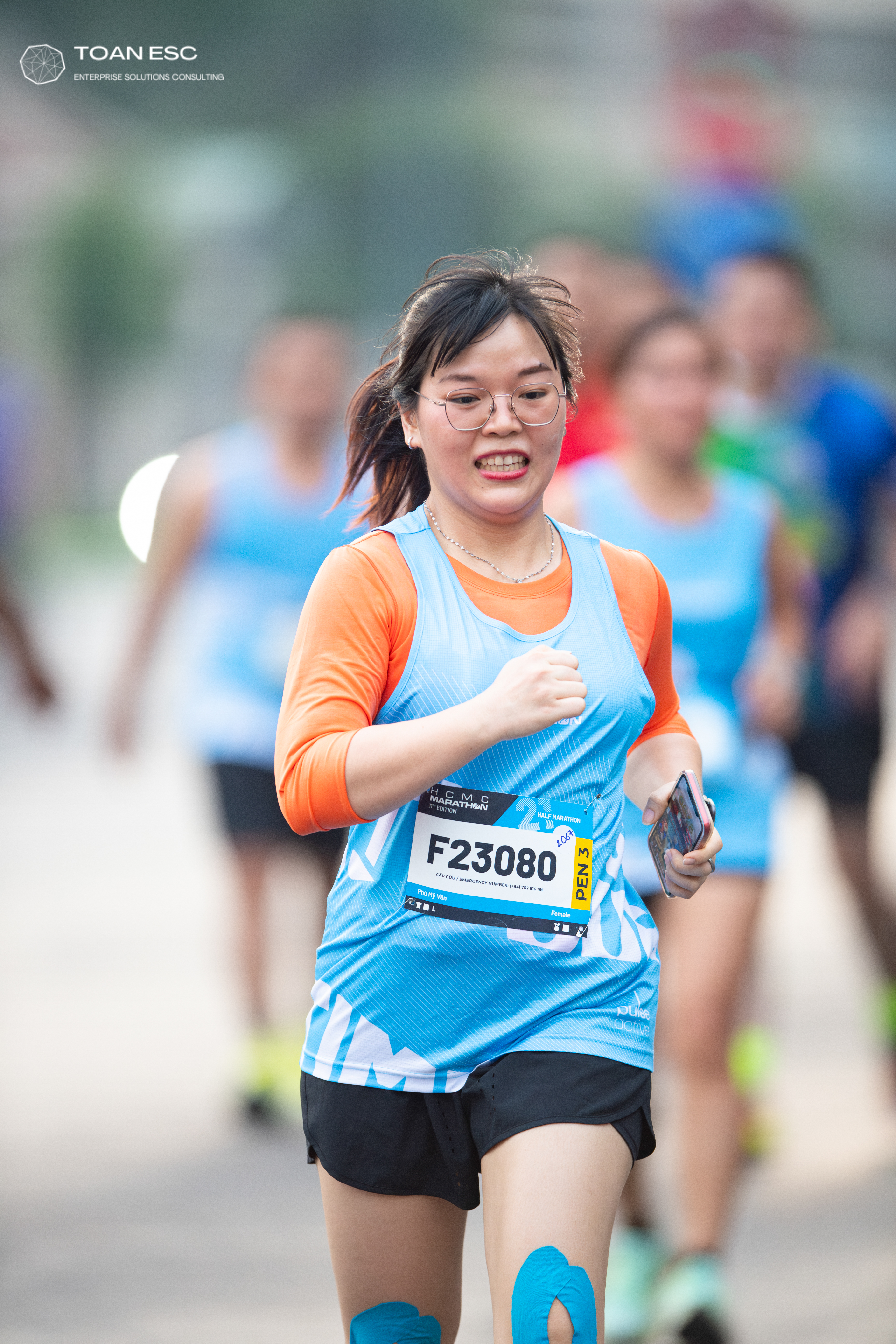 Marathon runner #F23080: Runner 1: light blue tank top, orange long-sleeved shirt, black shorts
