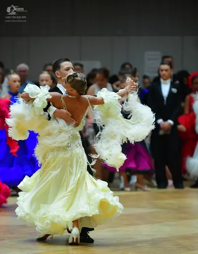 Dancesport competitor: Main female dancer: pale yellow/cream ballroom gown with a voluminous ruffled sk