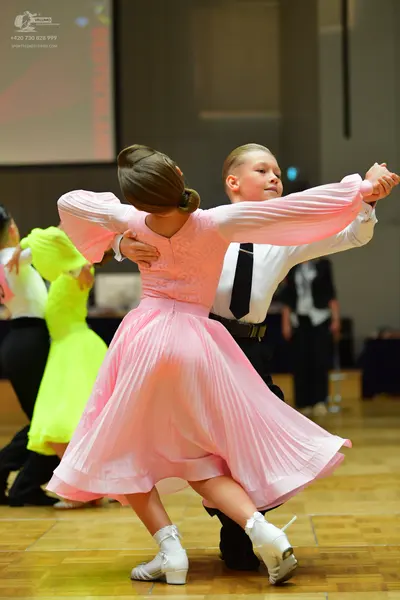 Dancesport competitor: Female dancer: long-sleeved, light pink pleated dress