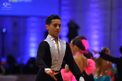 Dancesport competitor: Male dancer: black long-sleeved shirt with a large, silver sequined panel on the