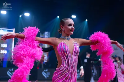 Dancesport competitor: Female dancer: bright pink latin dress with heavy pink sequin embellishments, a 