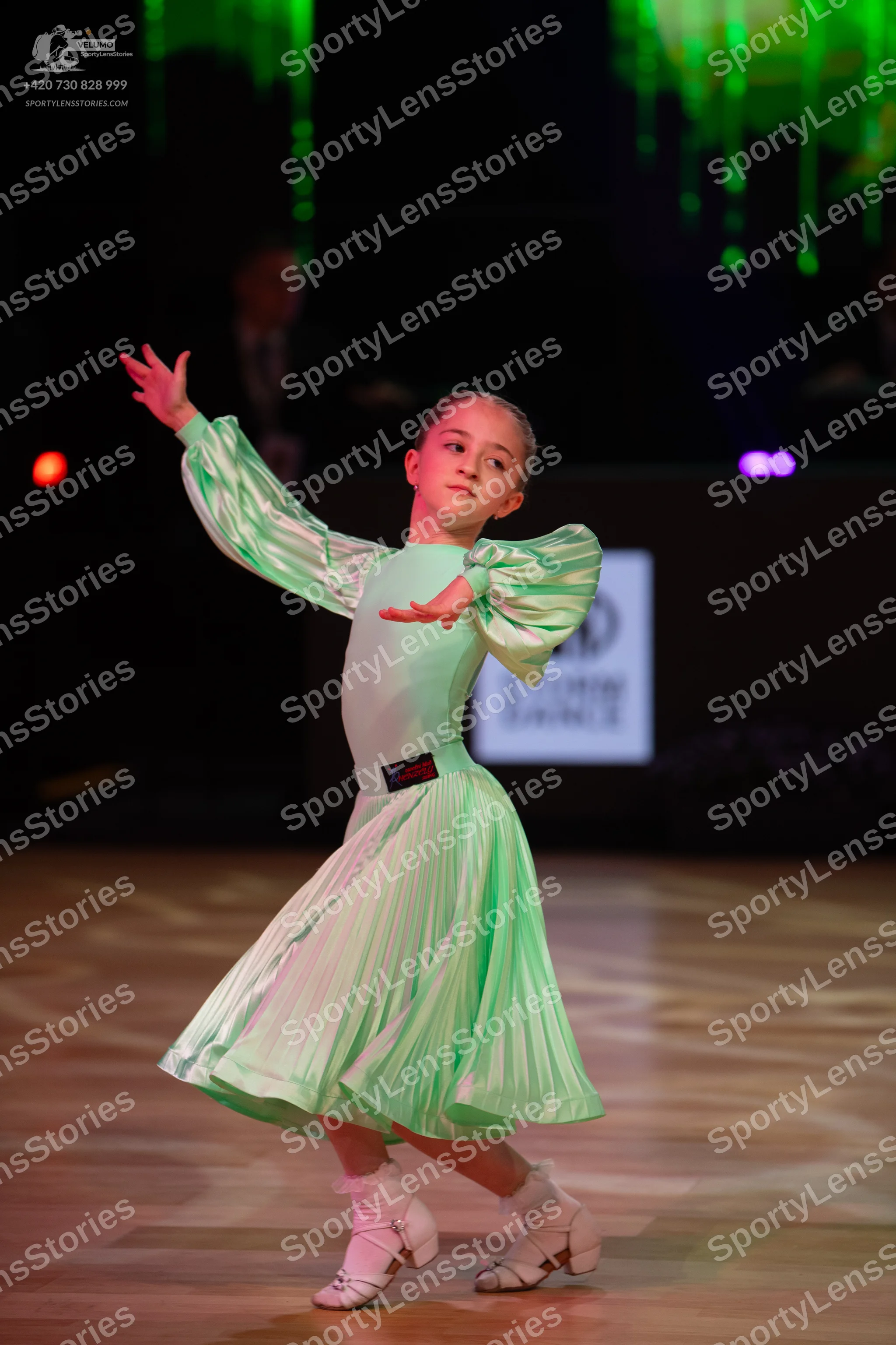 Dancesport competitor: Female dancer: mint green long-sleeved dress with puffy, pleated sleeves and a p