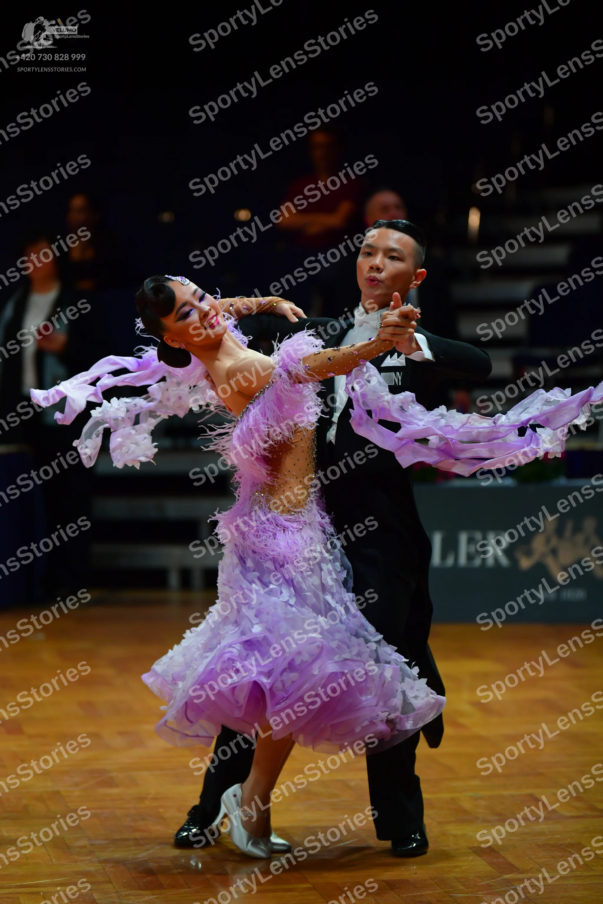 Dancesport competitor: Male dancer: black suit with white design on chest, black trousers, and black da
