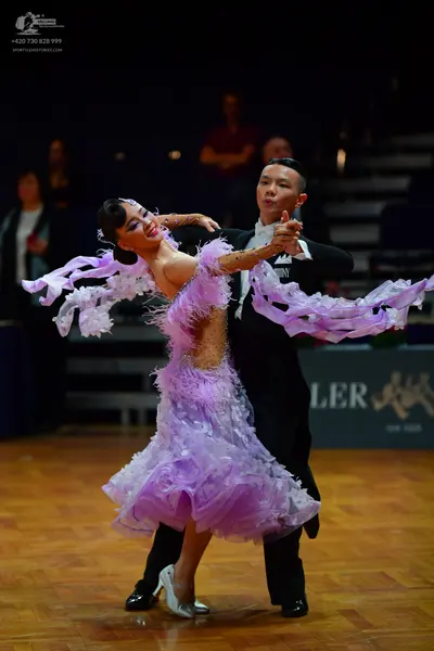 Dancesport competitor: Male dancer: black suit with white design on chest, black trousers, and black da
