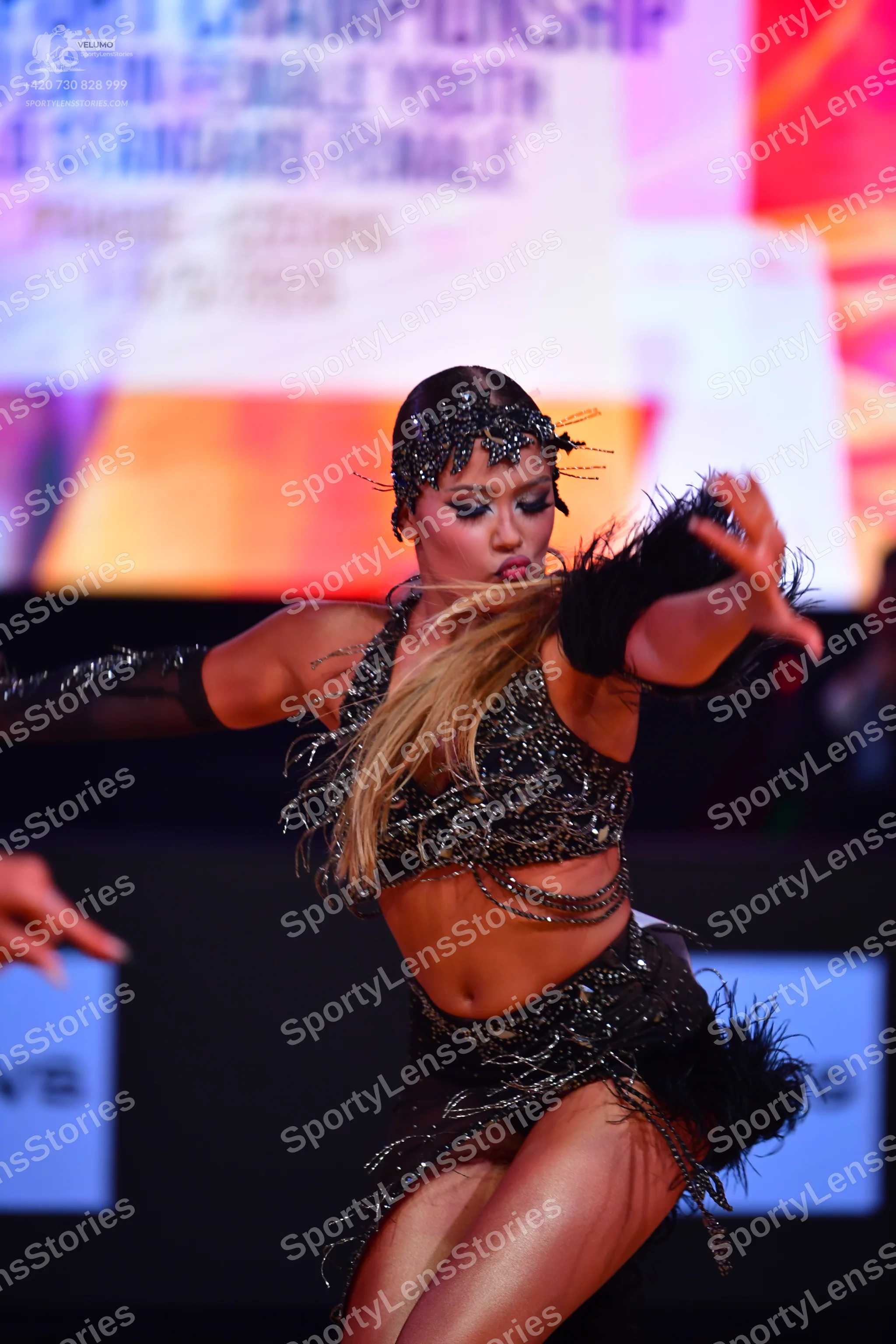 Dancesport competitor: Female dancer: black latin dance costume with sequins and long, thin fringe/stra