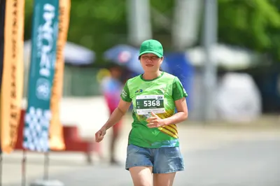 Marathon runner #5368: Runner 1: green cap, green jersey with yellow stripes, denim shorts
