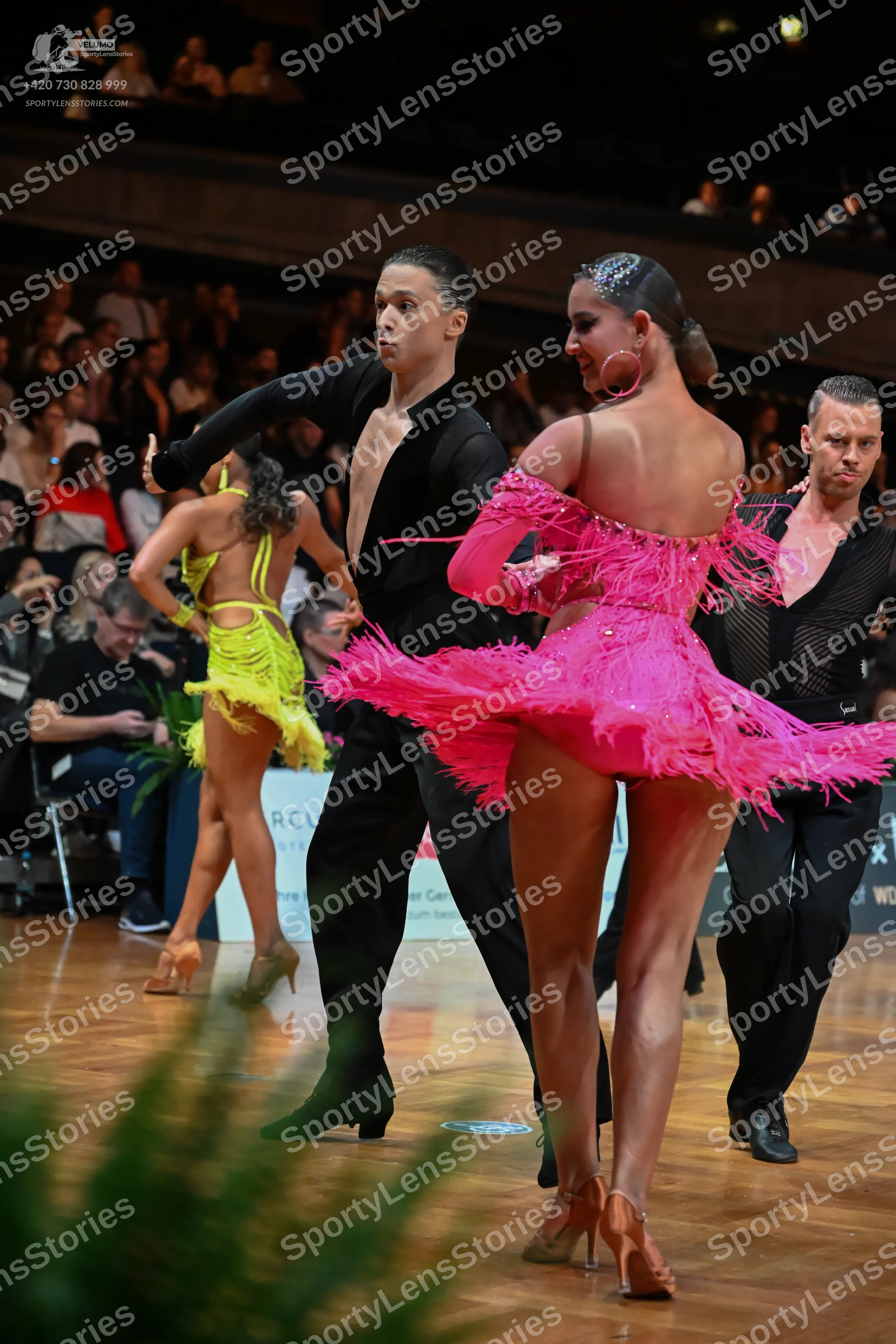 Dancesport competitor: Male dancer (center): black long-sleeved shirt with a deep V-neck and black trou