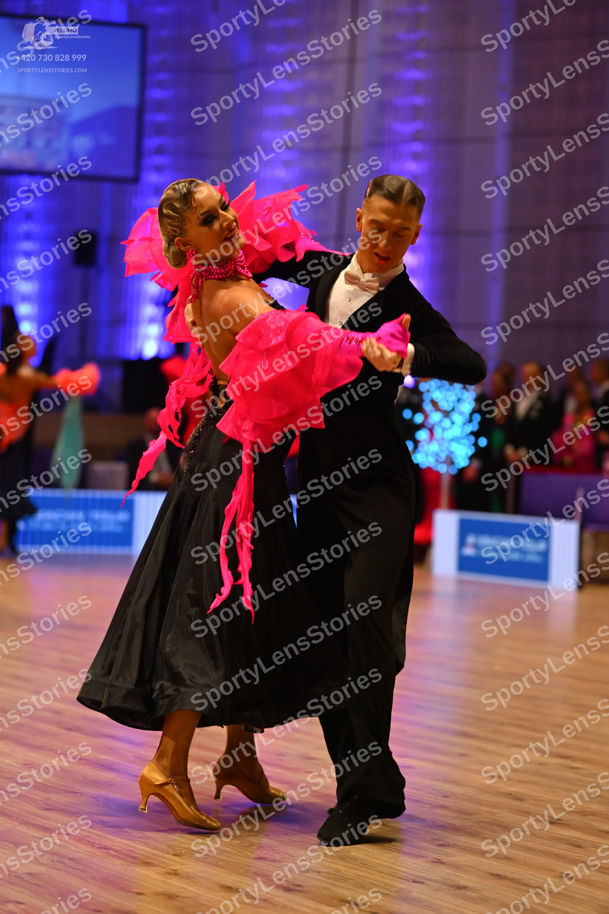 Dancesport competitor: Female dancer: vibrant pink ruffled/frilled top with large voluminous layers and