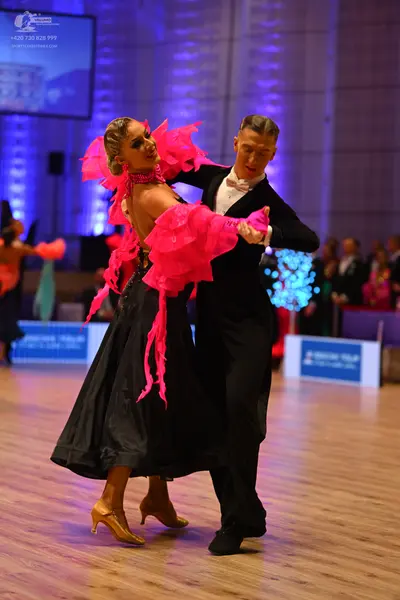 Dancesport competitor: Female dancer: vibrant pink ruffled/frilled top with large voluminous layers and