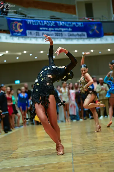 Dancesport competitor: Main dancer: black Latin dance dress with long sleeves, back cut-outs, and silve