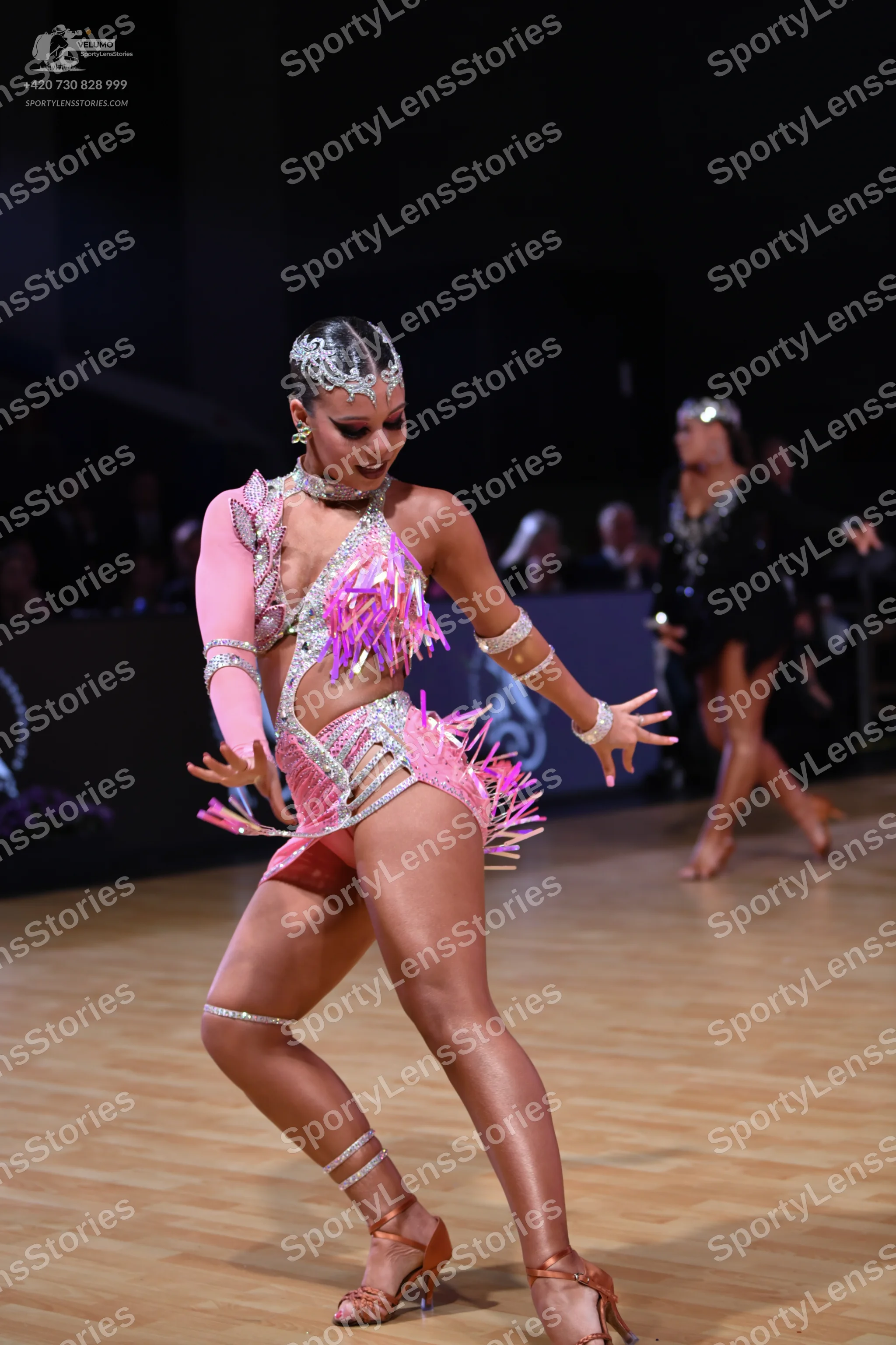 Dancesport competitor: Female dancer: pink latin dance costume with long, cut-out sleeves, heavily embe