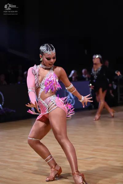 Dancesport competitor: Female dancer: pink latin dance costume with long, cut-out sleeves, heavily embe
