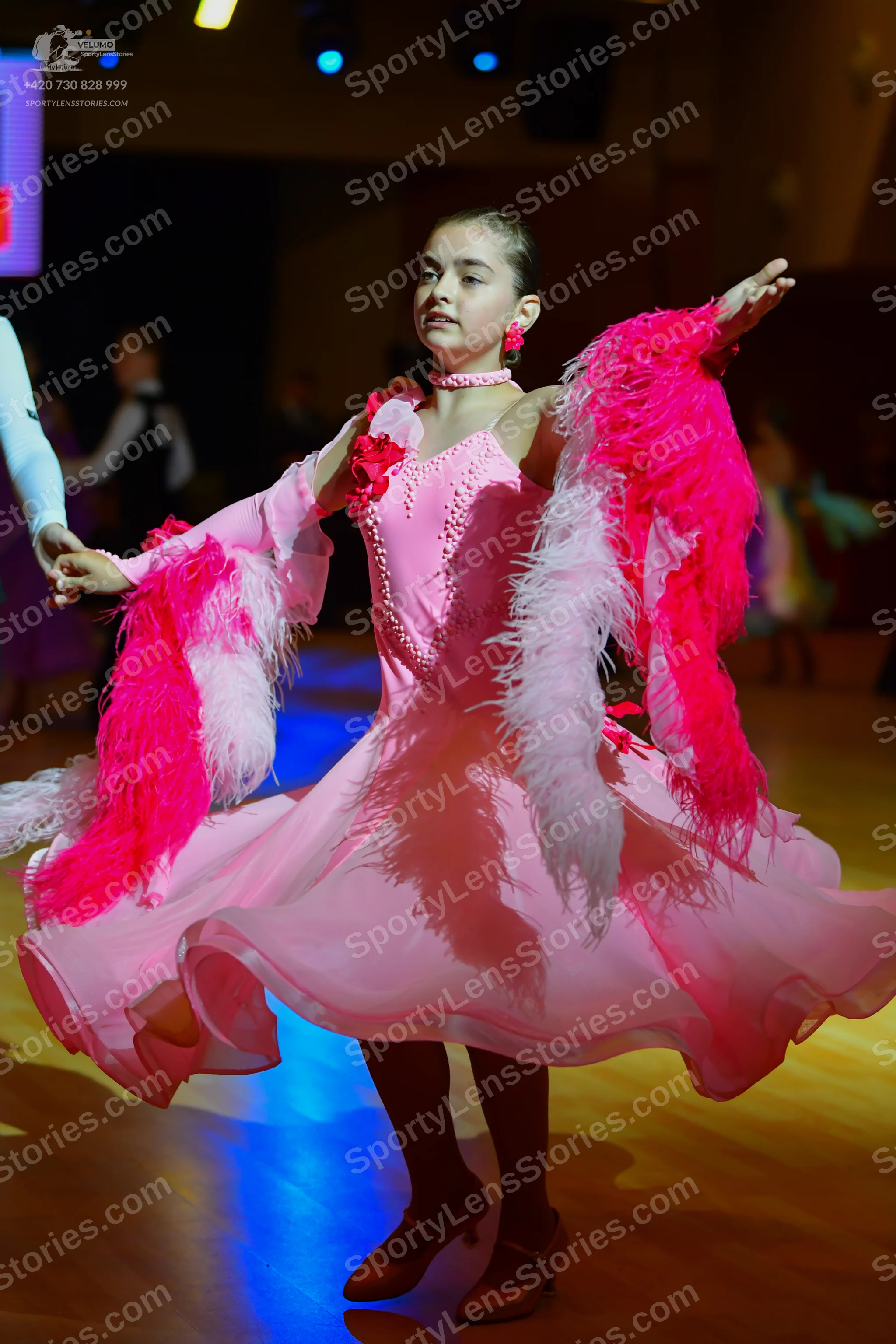 Dancesport competitor: Female dancer: pink ballroom dress with long sleeves covered in pink and white f