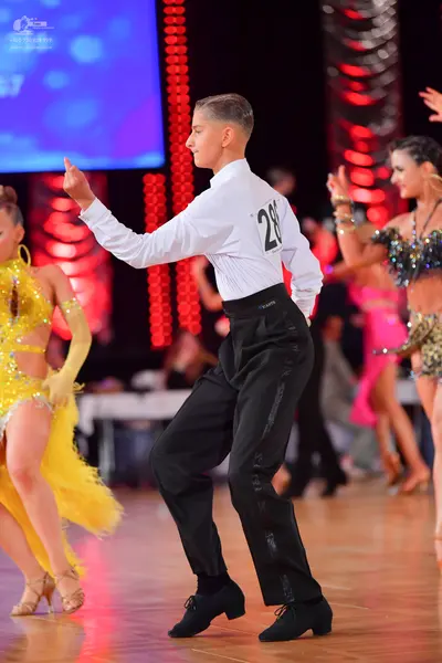 Dancesport competitor #28: Male dancer: white long-sleeved shirt and black trousers with a sequined stripe 