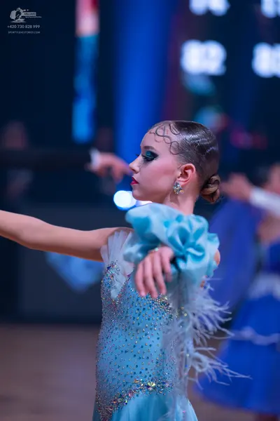 Dancesport competitor: Female dancer in foreground: light blue Latin dance dress with sequins, silver e