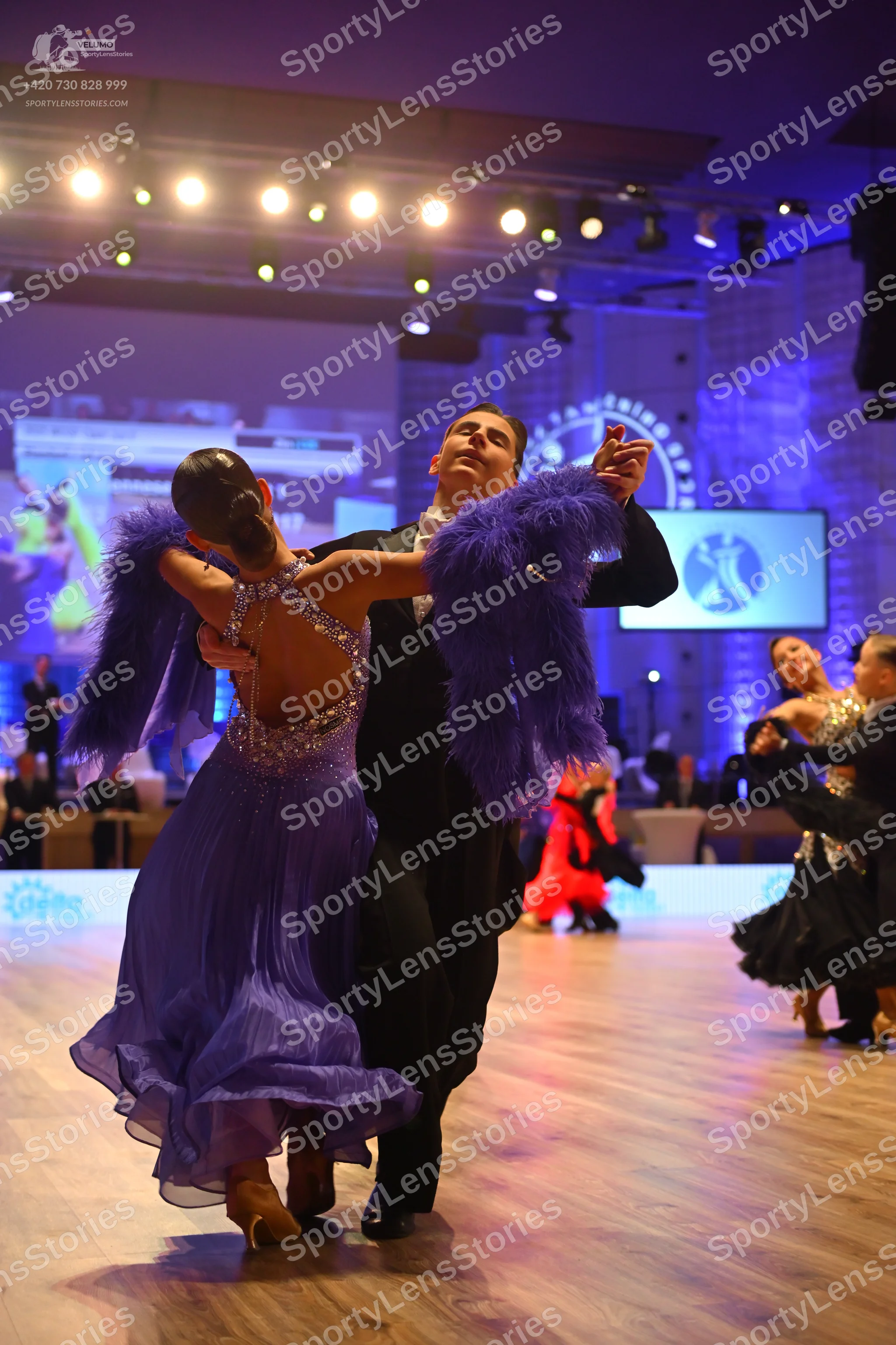 Dancesport competitor: Main female dancer: purple latin dress with a sequined bodice and large purple t