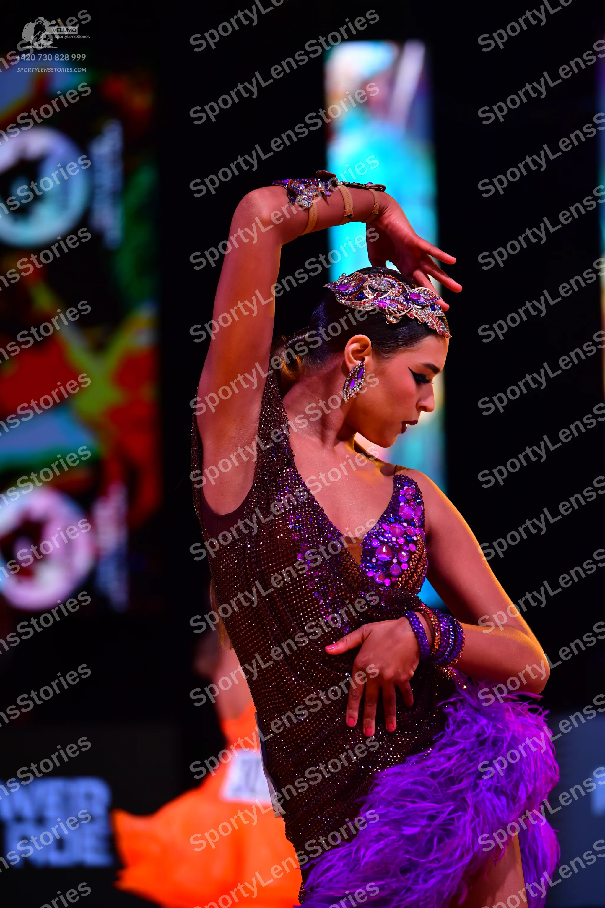 Dancesport competitor: Female dancer: dark purple/burgundy latin dress with sequins and purple feathers